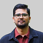 young man with short, dark hair and glasses