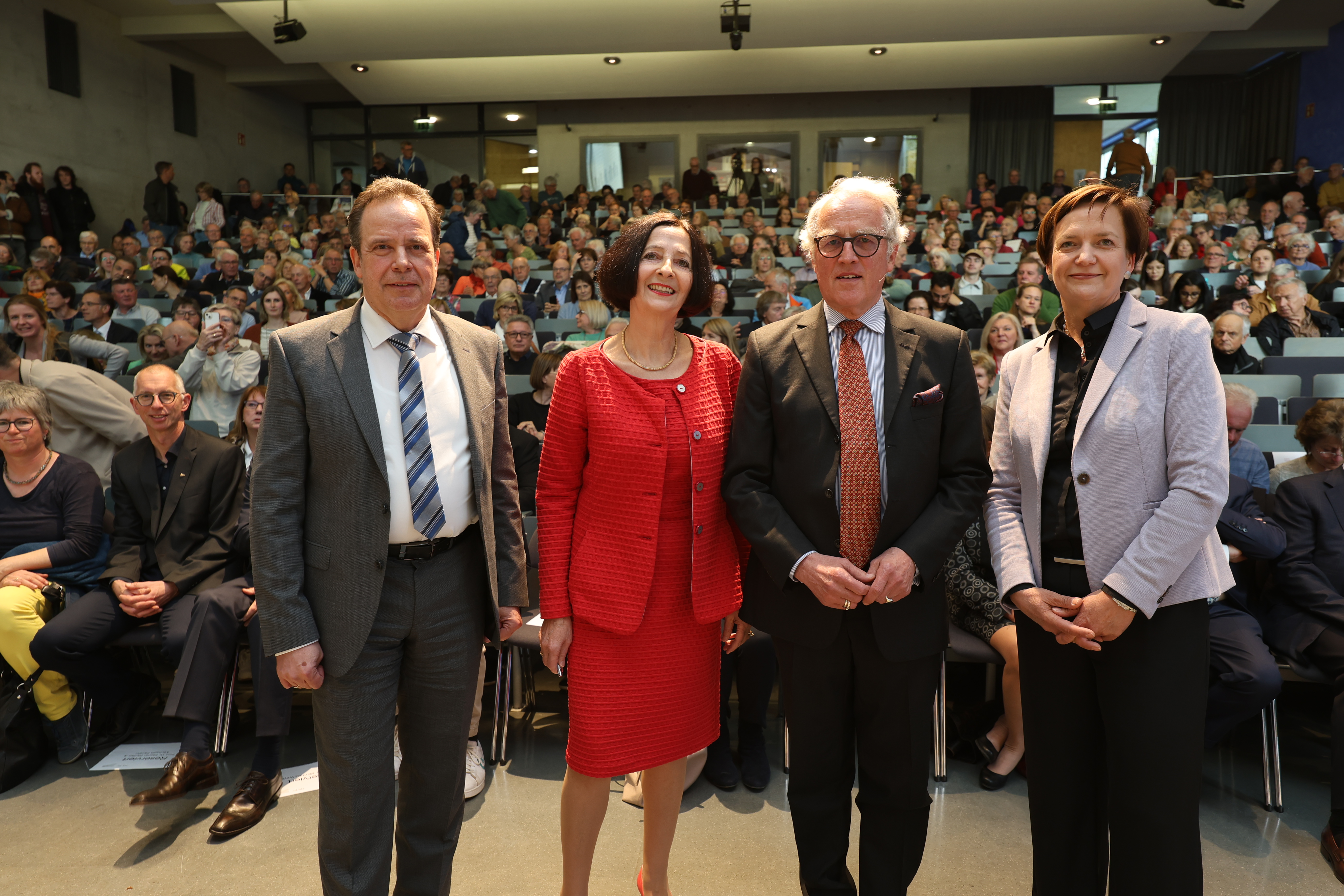 Organisatorinnen der Studium Generale Veranstaltungsreihe stehen mit Redner und Rektor der Hochschule vor gefülltem Saal