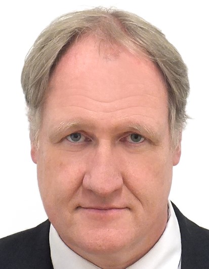 Herr mit grauem Haar schaut in die Kamera