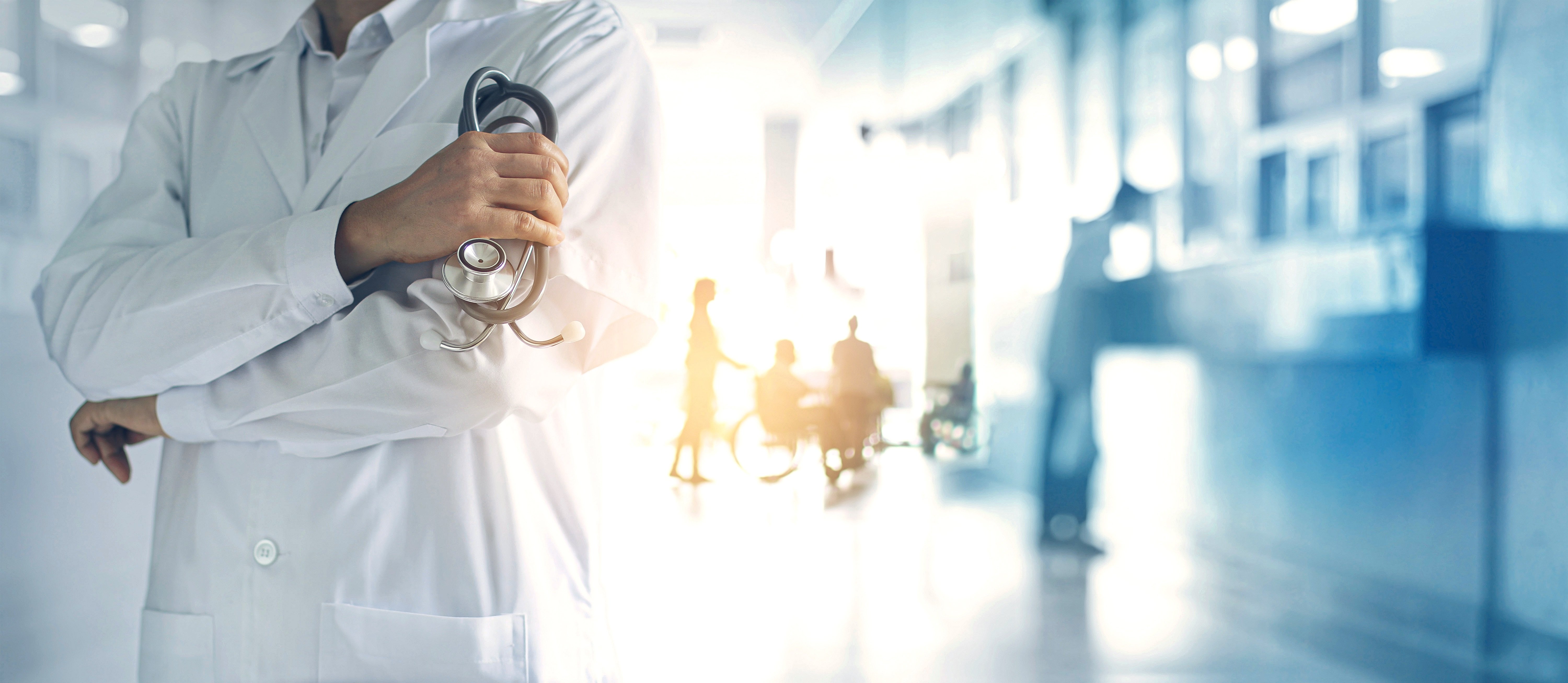 Arzt mit Stethoskop steht in Krankenhaus