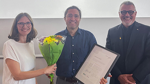 Preisträger Prof. Dr. Fernando Fastoso mit Urkunde und Blumenstrauß, links von ihm Prof. Dr. Anja Spilski, rechts Prof. Dr. Thomas Cleff
